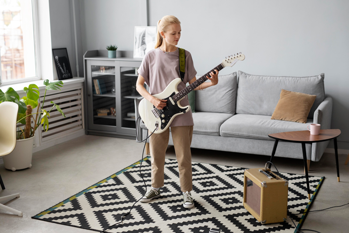 girl playing guitar in a Windsor apartment